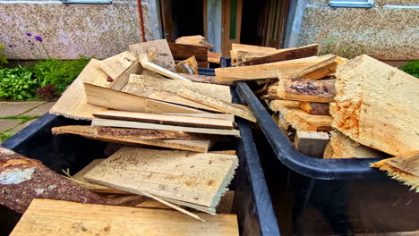 plastic bins filled with rough slab wood offcuts and barked scrap timber