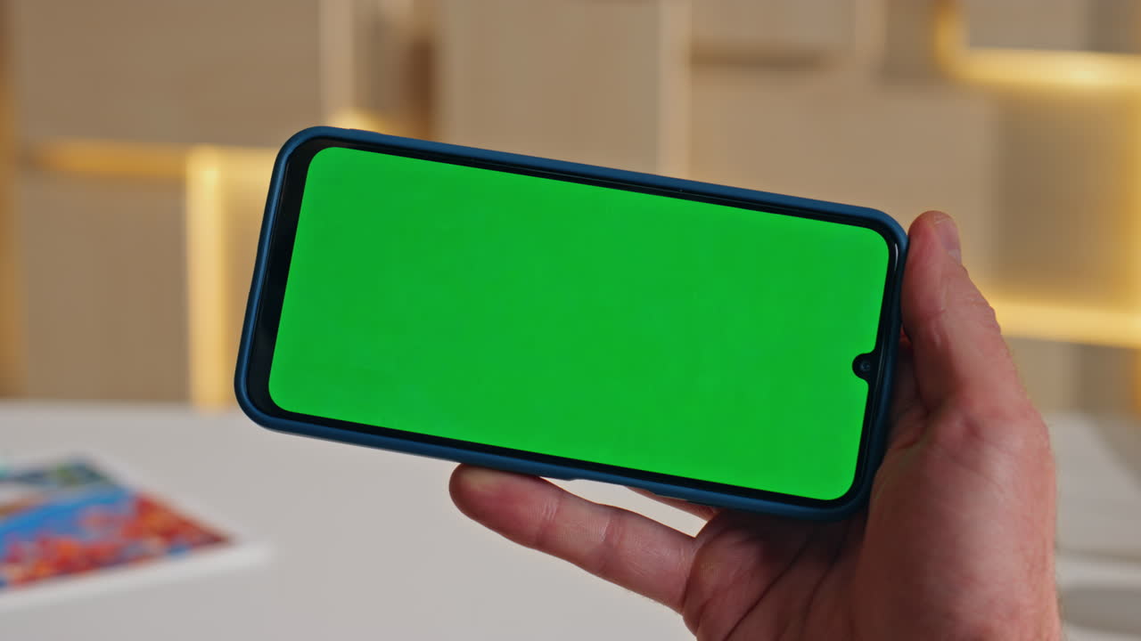 Freelancer browsing application chroma key mobile phone at workplace close up