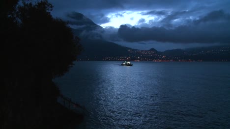 Un-Barco-Distante-Cruza-Un-Lago-Oscuro-Por-La-Noche