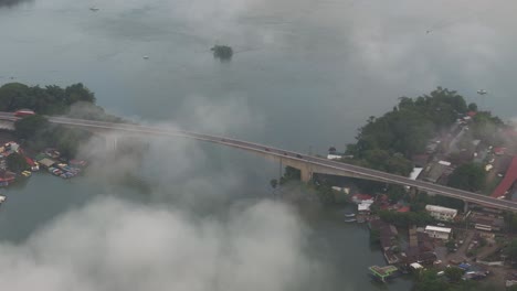 Puente-de-Río-Dulce-bridge-during-low-clouds-in-the-morning,-aerial