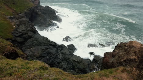 Blick-Von-Oben-Auf-Meereswellen,-Die-Auf-Felsen-Schlagen,-Felsklippenmeerblick-Am-Leuchtturmstrand,-Port-Macquarie,-Australien---Hochwinkelaufnahme