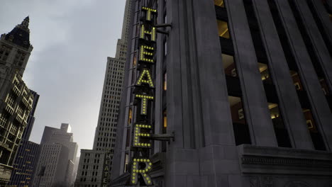 iconic theater sign glows against the urban skyline during dusk