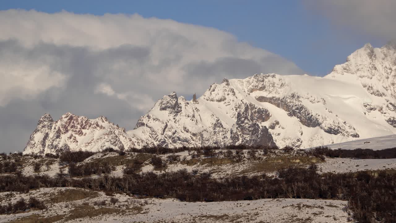 timelapse de la nieve cubierta cerro huemul con nubes y bosque debajo en invierno cerca de chalten, patagonia
