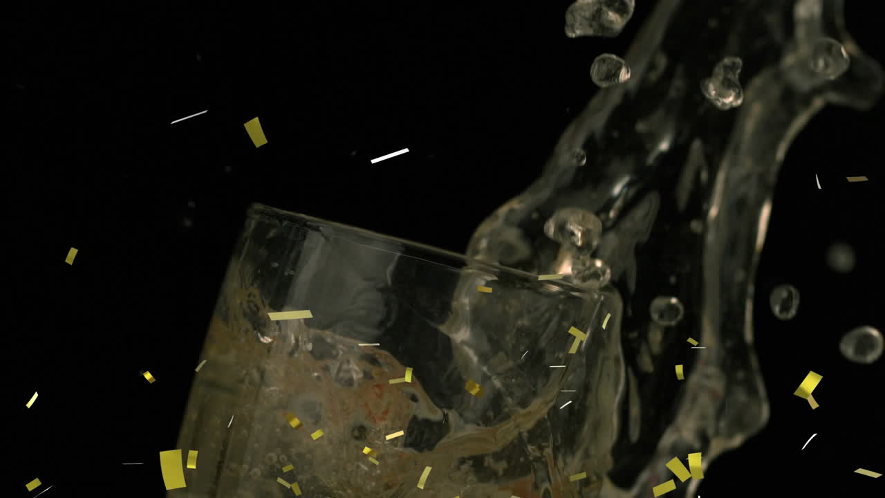 황금색 콘페티가 딸기 위에 떨어지고 검은색 배경에 페인 컵에 떨어집니다.