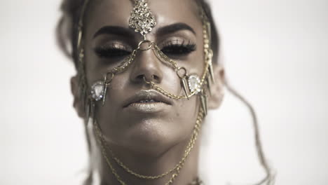 woman with elaborate gold jewelry and makeup