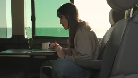 traveling woman working on laptop in van