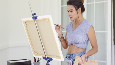 artistic young woman working on a painting