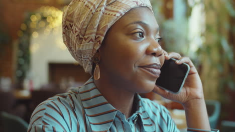 african american woman speaking on phone in cafe
