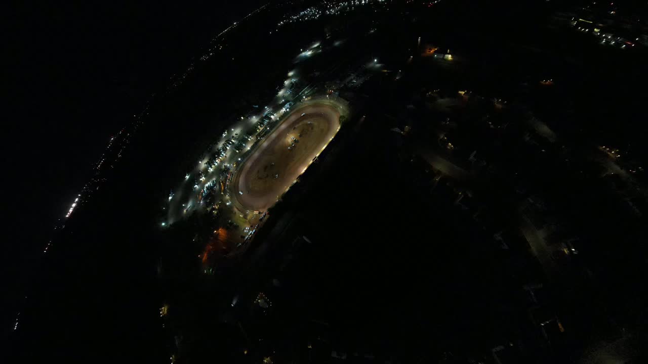 toma aérea de asteroides de carreras ovaladas de pista de tierra por la noche