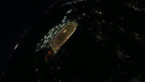 toma aérea de asteroides de carreras ovaladas de pista de tierra por la noche