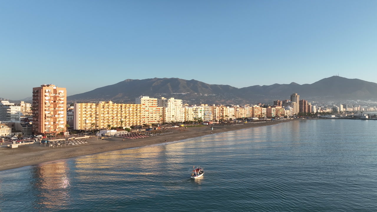 Aerial pans across the beachfront hotels and soft waves early morning Fuengirola
