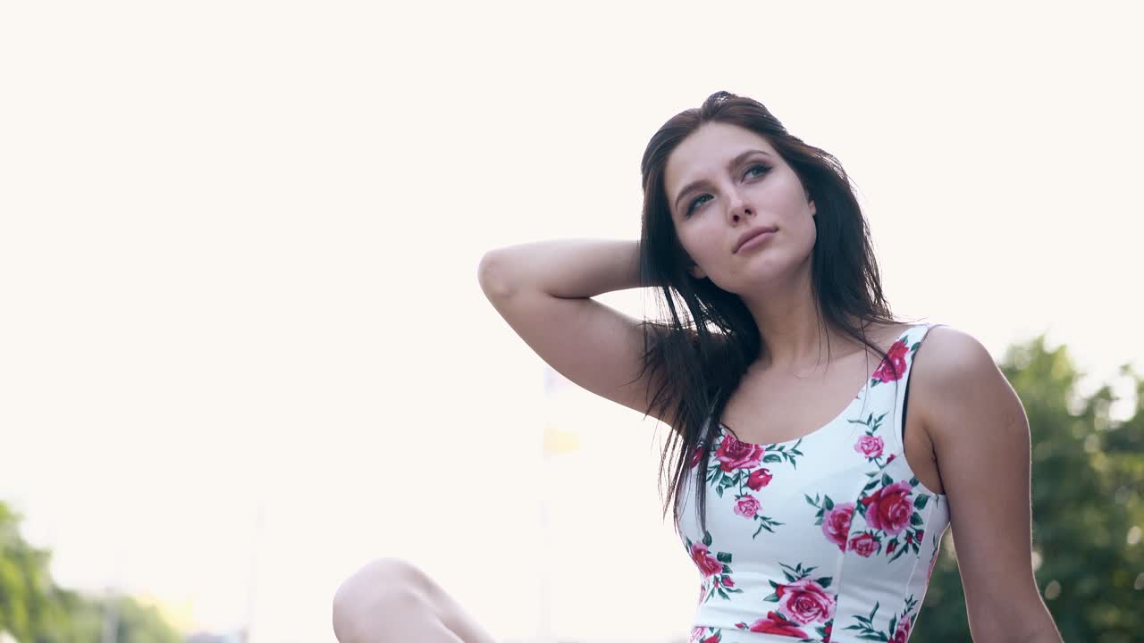 movimiento cercano alrededor de dama morena en vestido arreglando el cabello largo