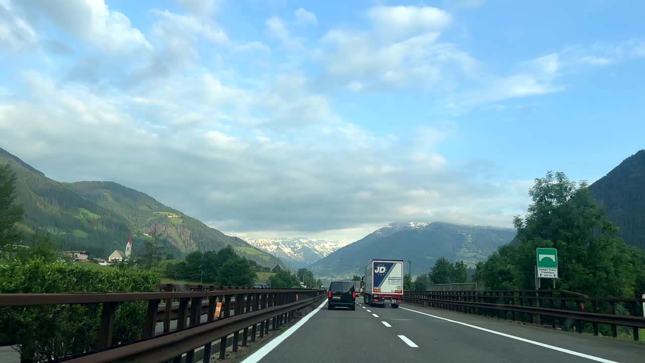 Driving on a highway through scenic mountains with trucks