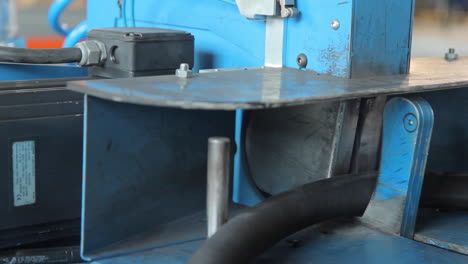 worker sawing rubber pipe on machine. industrial equipment at plant