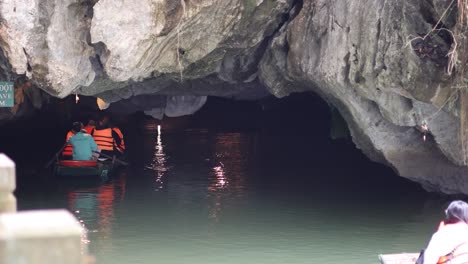 tourists on a boat exploring a dark cave