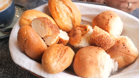 assorted bread rolls in a basket at a cafe