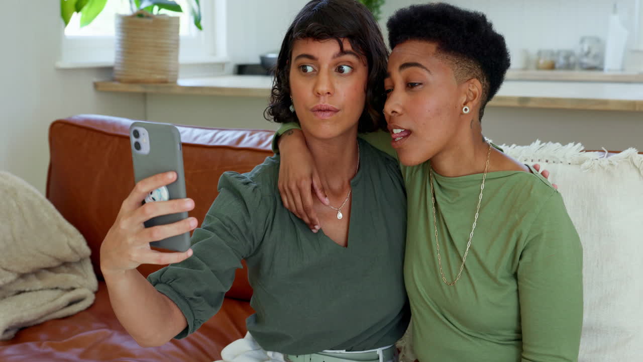 Telefono, selfie e coppia lesbica che si rilassa sul divano