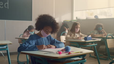 Niños-Con-Mascarillas-Estudiando-En-El-Aula-Durante-La-Pandemia-Del-Coronavirus