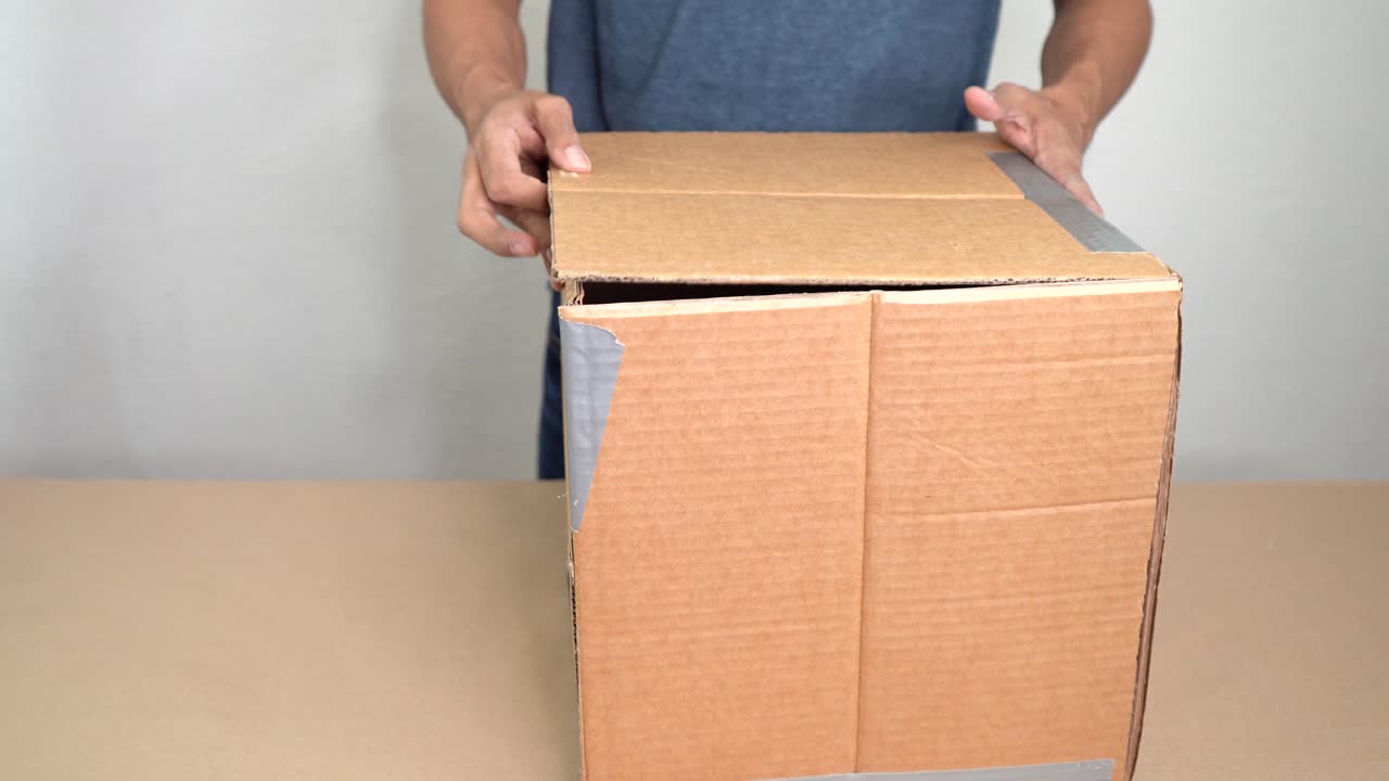 Crafting with cardboard, hands folding pieces creatively on table