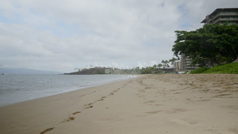 una vista estática de condominios de playa y hoteles en maui con olas rompiendo en la playa