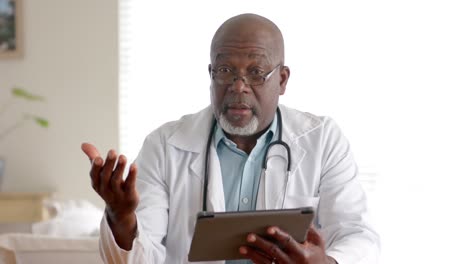 Médico-Afroamericano-Senior-Usando-Tableta-Haciendo-Videollamadas,-Cámara-Lenta