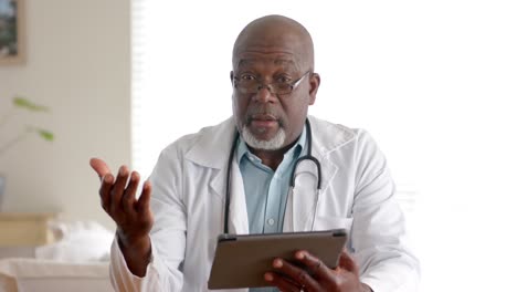 senior african american male doctor using tablet making video call, slow motion