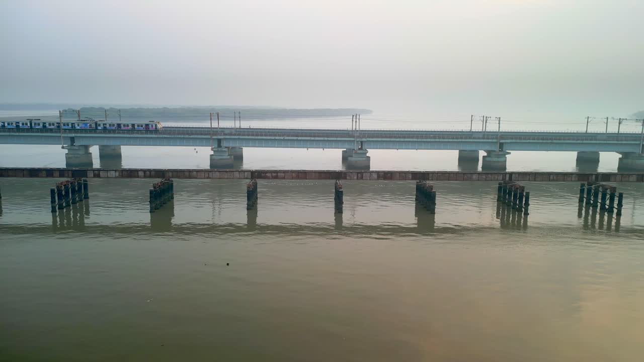 train going from naigoan to bhayandar on vasai creek bridge side closeup drone view