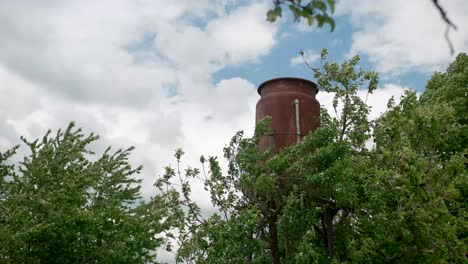 Rusted-old-water-tower-in-rural-countryside,-establisher