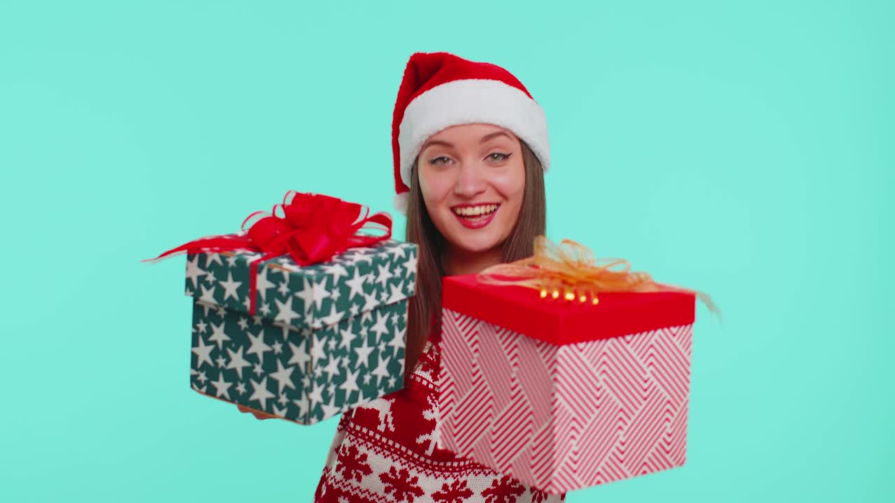 chica alegre en suéter de navidad rojo presentando dos cajas de regalos de navidad, compras víspera de venta de vacaciones