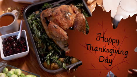 animation of happy thanksgiving day text on leaf over turkey and thanksgiving meal setting