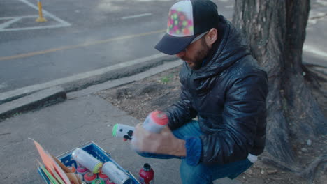 graffiti artist preparing spray paint for drawing on the street