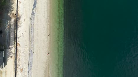 Vista-De-Pájaro-De-Una-Pareja-En-La-Orilla-Del-Mar-De-La-Playa-De-Owen-En-Un-Día-De-Verano-En-Tacoma,-Washington