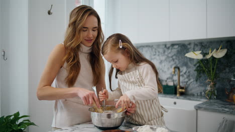 Lovely-woman-baby-cooking-at-kitchen-together-closeup.-Family-preparing-dough