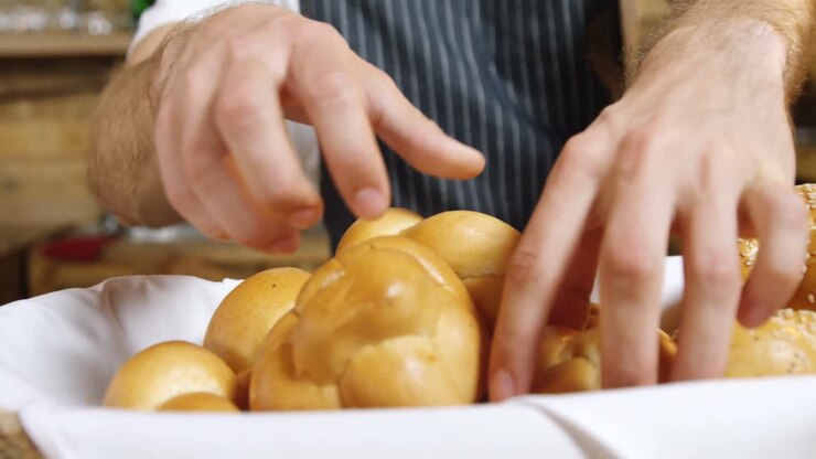 Male waiter arranging bread rolls at counter 4k