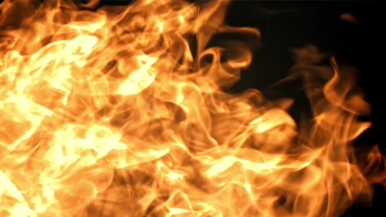 Intense flammer brænder og spreder sig på en sort baggrund