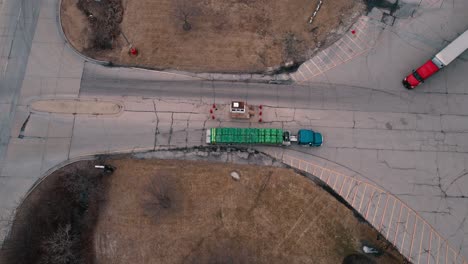 Flatbed-Semi-truck-driver-enters-truck-stop-while-red-tractor-with-white-trailer-exits