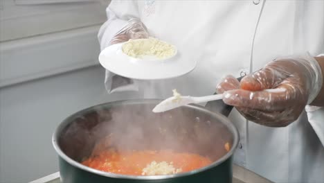 Un-Chef-Cocina-En-Una-Sartén-Y-Le-Agrega-Ajo-Después-De-Recogerlo-De-Un-Plato