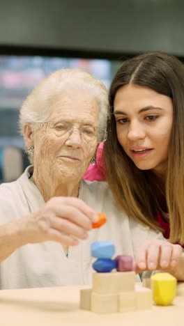 senior woman playing blocks with caregiver