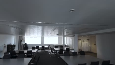 a panoramic view of the empty boardroom or conference room, adorned with chairs and tables, the professional ambiance and potential collaboration inherent in corporate environments