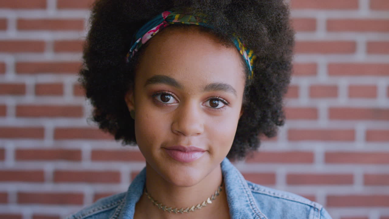 mujer negra, cara y moda afro en la pared de ladrillo