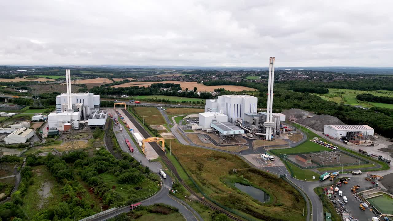 Filmato aereo realizzato con drone che si allontana da impianti di energia multi-combustibile da rifiuti nell'Inghilterra settentrionale rurale, che mostra infrastrutture energetiche industriali e temi di gestione dei rifiuti e produzione di energia