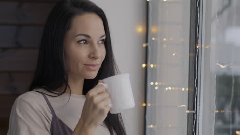 mujer disfrutando de café junto a la ventana