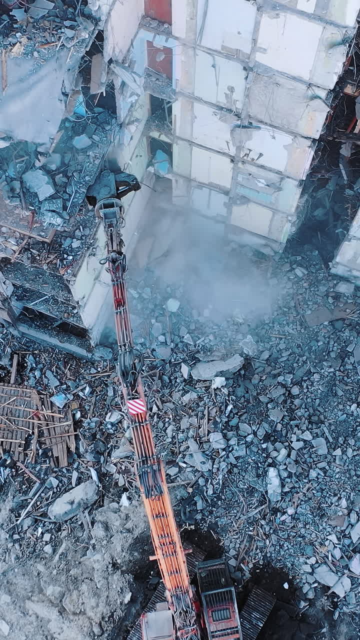 Construction of destroyed house. Destructive demolition building by excavator. Vertical video