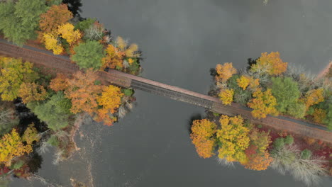 rotation overhead of railroad bridge surrounded by autumnal trees