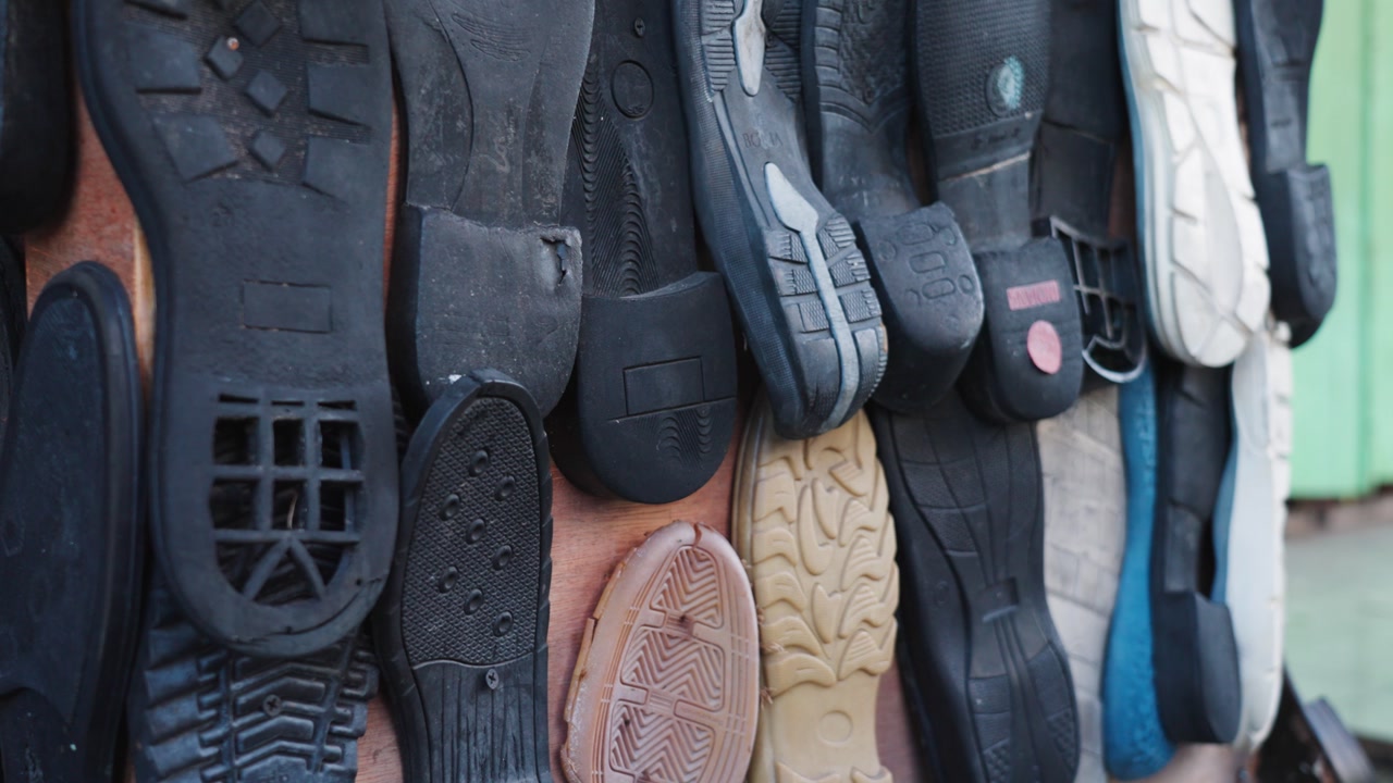 Slow motion close-up of various rubber shoe outsoles in Kuala Lumpur, Malaysia, showcasing textures, patterns, and materials used in footwear manufacturing and design.