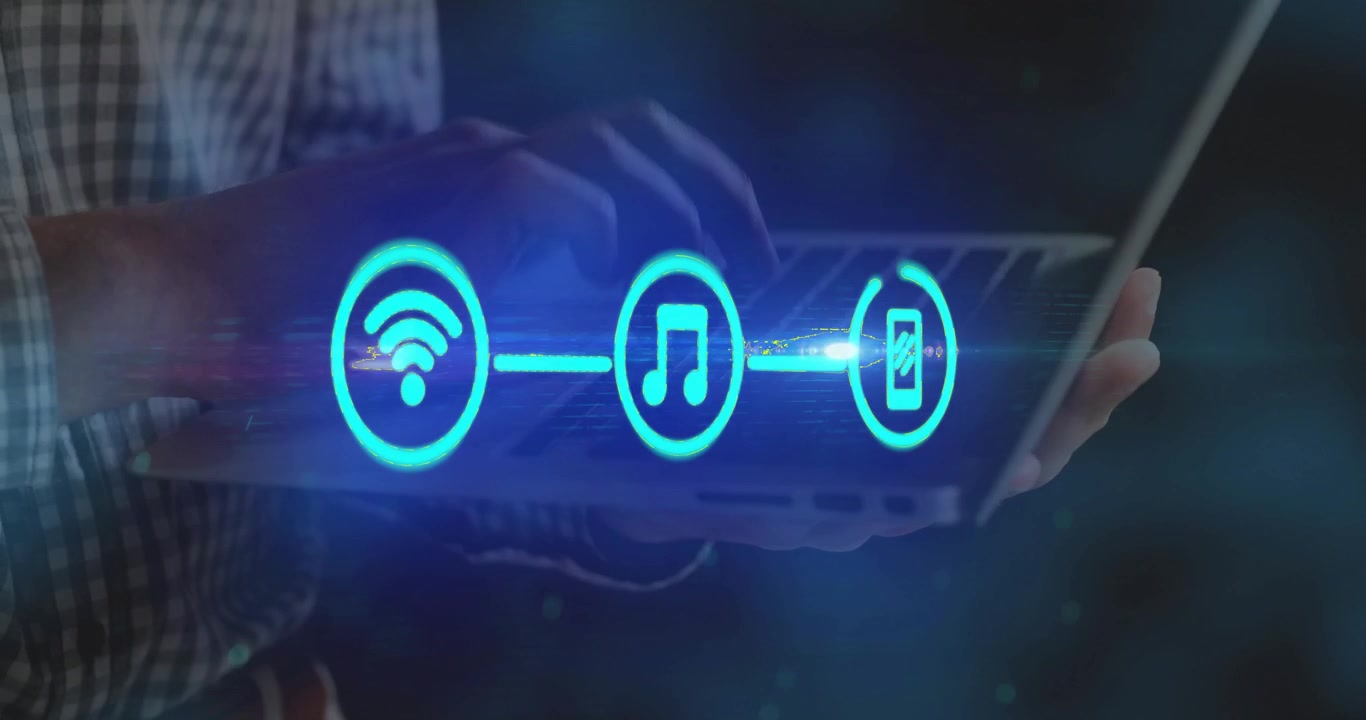 Uomo che digita al laptop in un ambiente di lavoro tecnologico, con un anello di progresso pulsante che genera icone di smartphone per musica wireless.