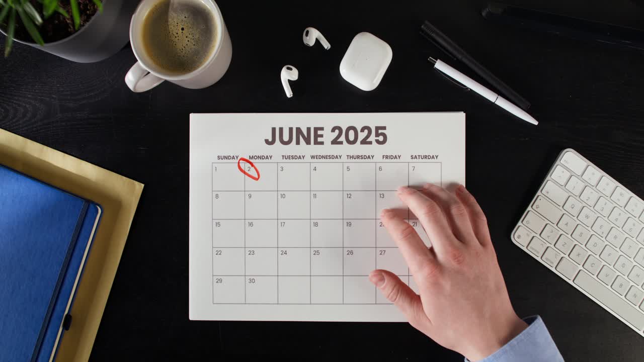 Person marking date on a June 2025 calendar