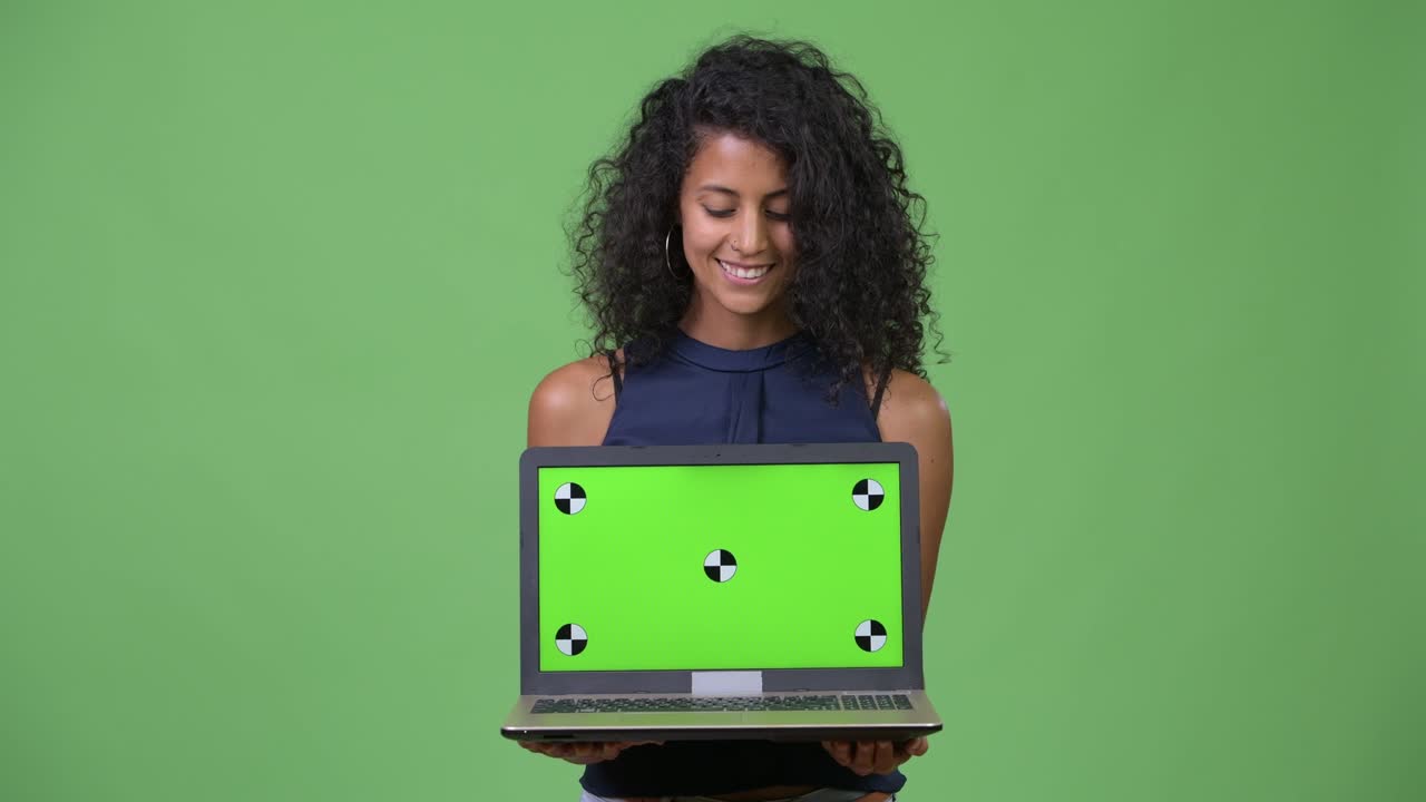 Young beautiful Hispanic businesswoman showing laptop