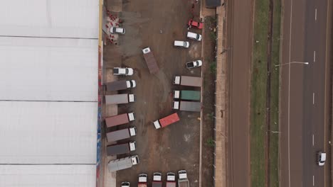 patio de la fábrica con varios camiones estacionados y otro entrando al parque