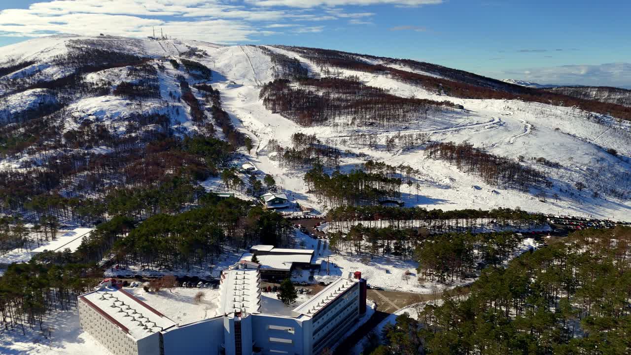 Luftfoto av Manzaneda Ski Resort i Galicia som viser snødekte bakker og nærliggende skogområder som er i ferd med å komme seg etter store brannskader.
